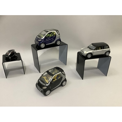 26 - A Saico model of a Mini Cooper 2001, 14.5cm long, a Maisto Smart City coupé, silver and black, 13cm ... 