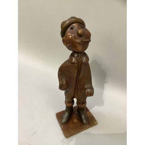 54 - An Italian carved hardwood figure of a man smoking a cheroot, a hat on his head, a knapsack on his b... 