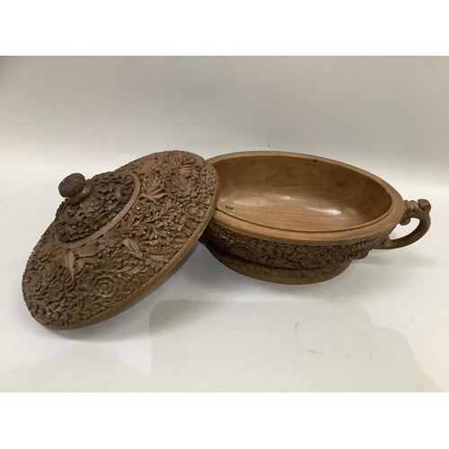 68 - A 20th century Indian carved hardwood two handled bowl and domed cover, all over carved with flowers... 