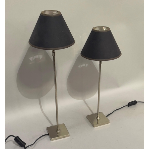 172 - A pair of chrome table lamps of graduated size, on square bases, and having adjustable heads with bl... 