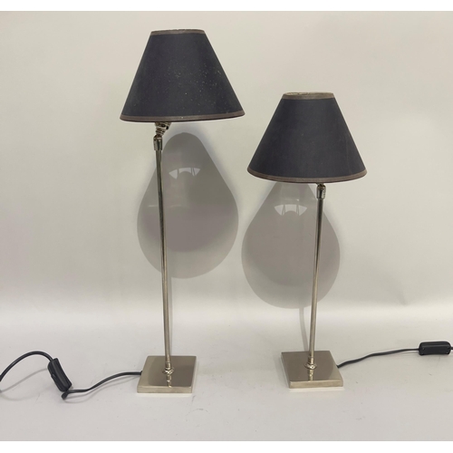 172 - A pair of chrome table lamps of graduated size, on square bases, and having adjustable heads with bl... 