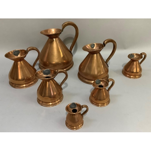 89 - A set of seven copper jugs of graduated size from half-gallon, quart, pint, half-pint, one gill, hal... 