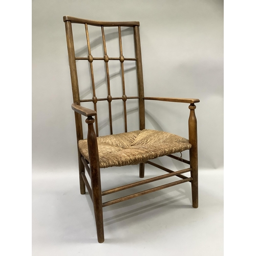 162 - An early 20th century polished beechwood and rush seated open armchair