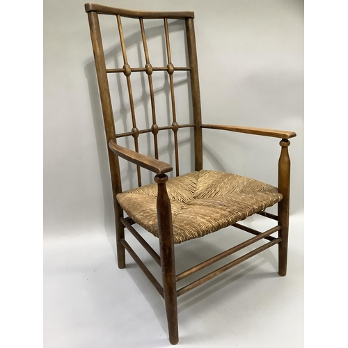 162 - An early 20th century polished beechwood and rush seated open armchair