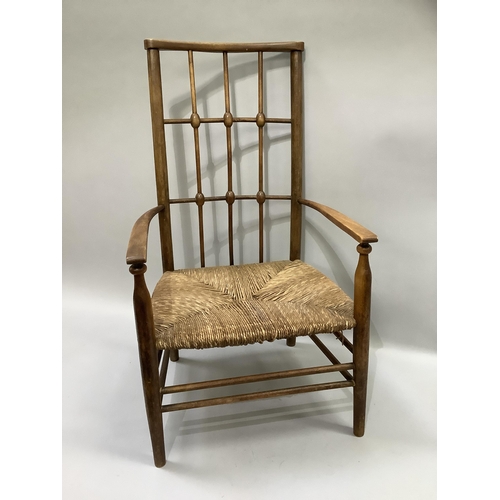 162 - An early 20th century polished beechwood and rush seated open armchair