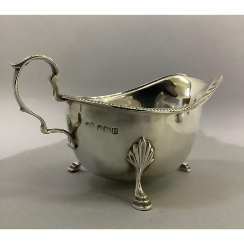 388 - A silver sauceboat by J R Ogden of Harrogate with three pad feet, C scroll handle and beaded rim, ap... 