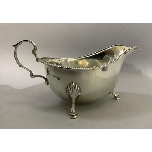 388 - A silver sauceboat by J R Ogden of Harrogate with three pad feet, C scroll handle and beaded rim, ap... 