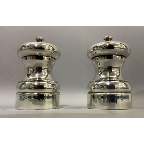 386 - A pair of silver salt and pepper mills of circular baluster form hallmarked London 1993 and 1994 for... 