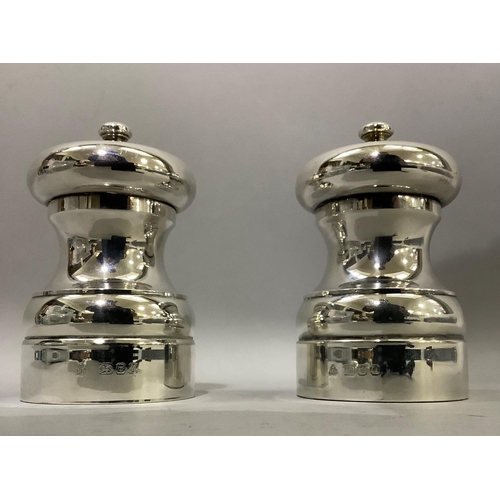 386 - A pair of silver salt and pepper mills of circular baluster form hallmarked London 1993 and 1994 for... 