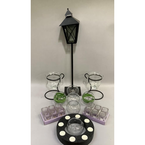 261 - A pair of glass candle lamps in black metal holders together with a sectional ring of tealights in b... 