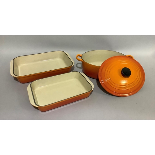 148 - A Le Creuset orange enamel two-handled casserole pan and cover, 37cm over handles and  two lasagne d... 