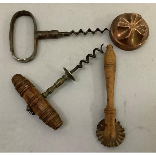 69 - Two antique corkscrews, a pastry crimper and a small copper mould