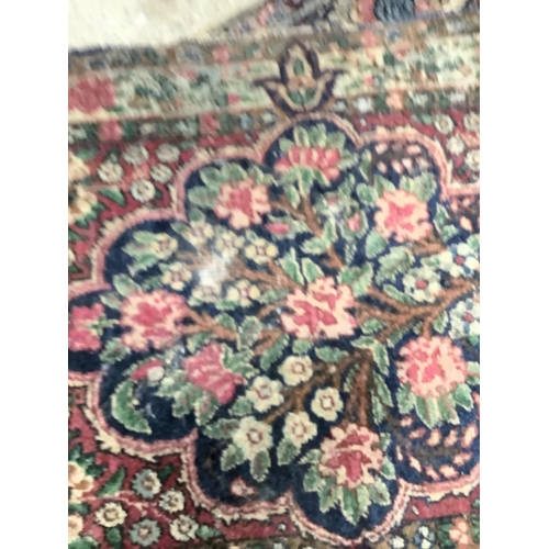 110 - A pair of Persian style rugs, the ivory ground woven with a design of blossom in blue, rose, ochre a... 