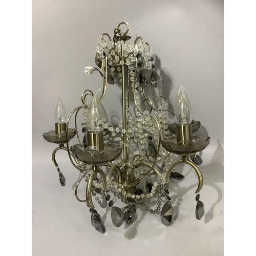 245 - A pair of pale gilt metal five light chandeliers having scrolling arms with tinted glass sconces, ca... 