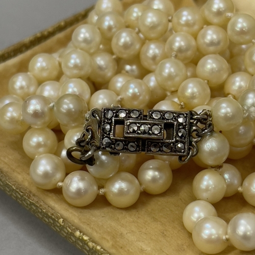 415 - A cultured pearl necklace, the three rows of 6mm diameter pearls fastened with a marcasite set silve... 