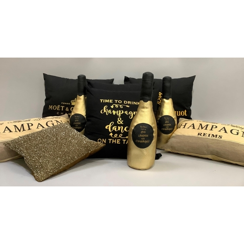 317 - Seven cushions, four in black with yellow/gold champagne brands and messages, two rectangular cushio... 