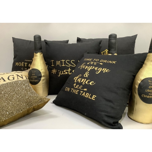 317 - Seven cushions, four in black with yellow/gold champagne brands and messages, two rectangular cushio... 