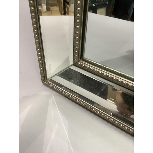 333 - A rectangular wall mirror with mirrored and beaded frame, 130cm high x 40cm wide