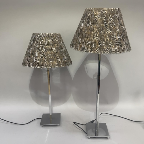 340 - A pair of polished steel and feather table lamps with telescopic columns for height adjustment, on s... 