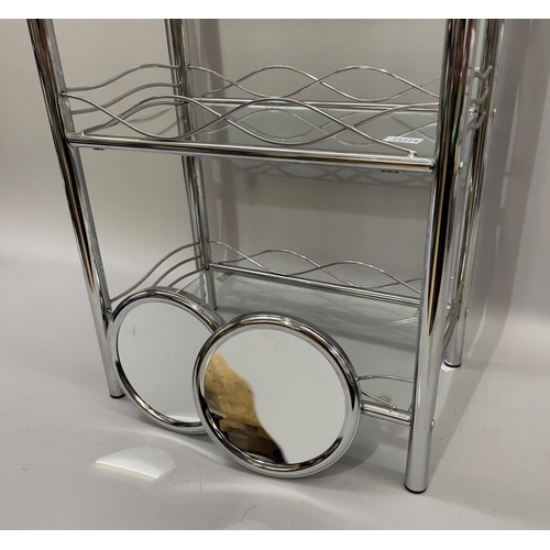 377 - A chrome four tier bathroom stand together with a pair of circular suction bathroom mirrors