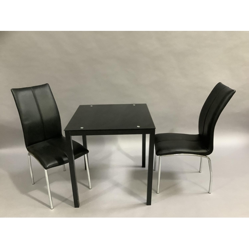 452 - A black glass kitchen table and two black leather and chrome legged dining chairs, 701cm square