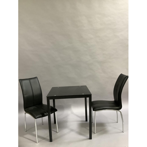 452 - A black glass kitchen table and two black leather and chrome legged dining chairs, 701cm square