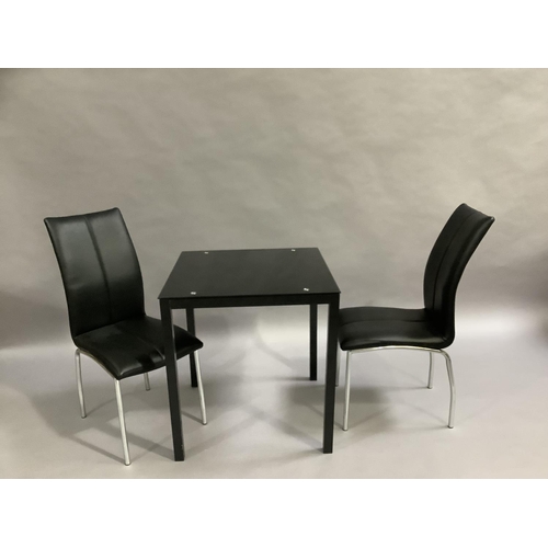 452 - A black glass kitchen table and two black leather and chrome legged dining chairs, 701cm square