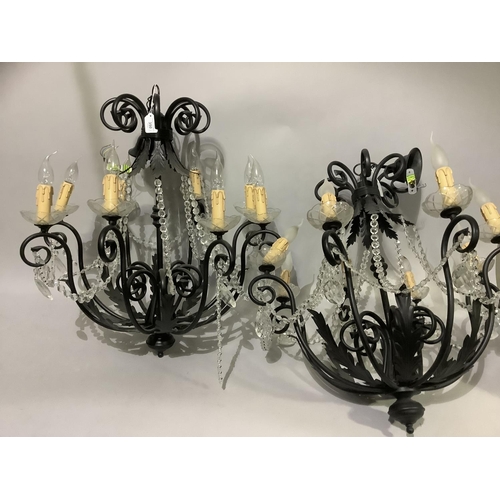 350 - A pair of eight light chandeliers with black metal scrolling arms and leafage, glass sconces, candle... 