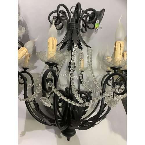 350 - A pair of eight light chandeliers with black metal scrolling arms and leafage, glass sconces, candle... 