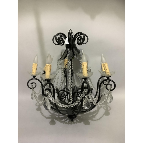 351 - A pair of eight light candelabra with black metal scrolling arms and leafage, glass sconces, candle ... 