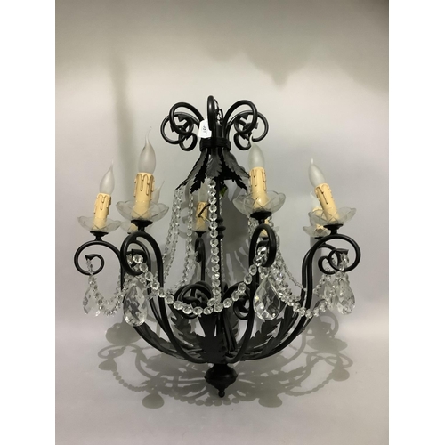 351 - A pair of eight light candelabra with black metal scrolling arms and leafage, glass sconces, candle ... 