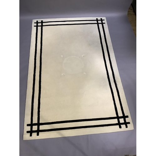 374 - A cream wool rug with twin black line border, 290cm x 200cm