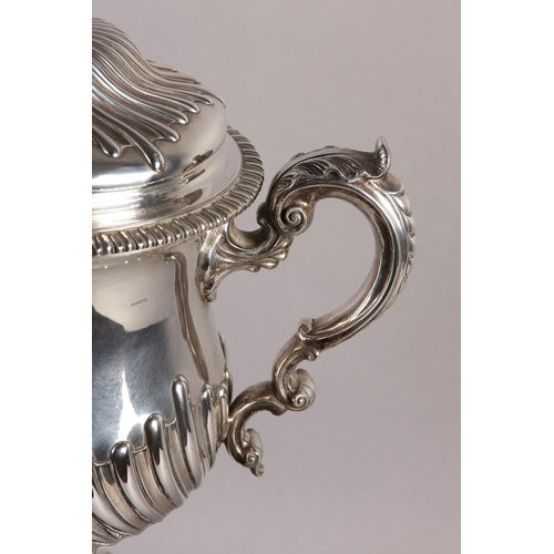 196 - A VICTORIAN SILVER TROPHY CUP with domed lid and two foliate c-scroll handles, wrythen chased to the... 