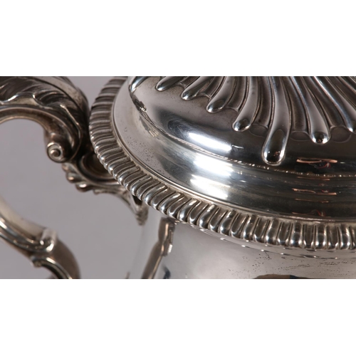 196 - A VICTORIAN SILVER TROPHY CUP with domed lid and two foliate c-scroll handles, wrythen chased to the... 