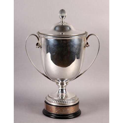 197 - A GEORGE V SILVER TROPHY CUP and domed cover with acorn finial, twin loop handles, gadroon rims, rai... 