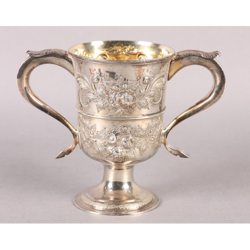 194 - A GEORGE III SILVER TROPHY CUP with rose chasing, banded with foliate c-scroll handles, later engrav... 