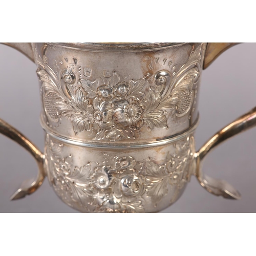 194 - A GEORGE III SILVER TROPHY CUP with rose chasing, banded with foliate c-scroll handles, later engrav... 