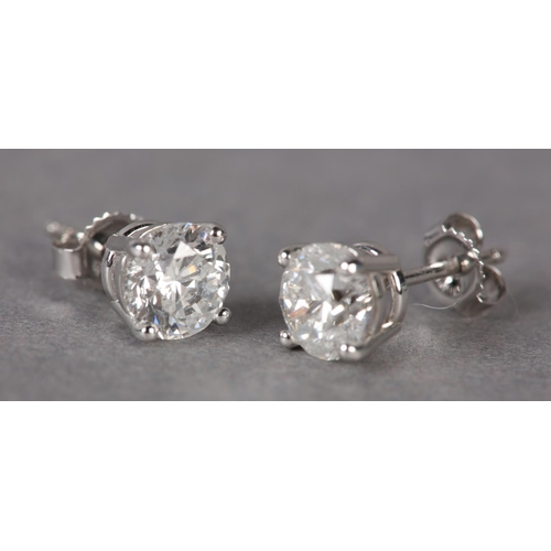 302 - A PAIR OF DIAMOND STUD EARRINGS, the brilliant cut stones claw set in white metal (tests as 18ct gol... 