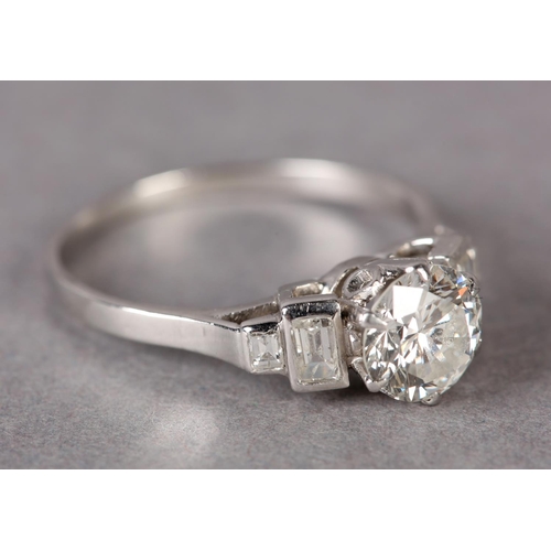 303 - A DIAMOND RING in platinum c.1950, the brilliant cut principal stone claw set and flanked by four gr... 