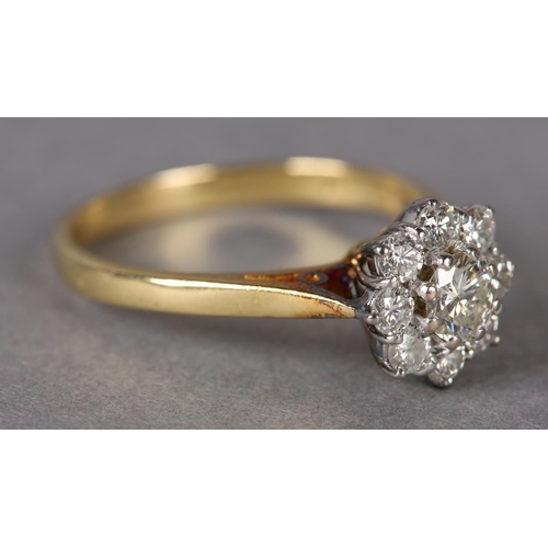 305 - A DIAMOND CLUSTER RING in 18ct yellow and white gold, the brilliant cut stones claw set within a cir... 