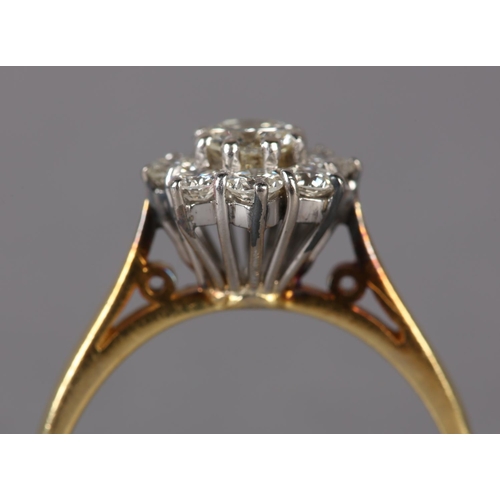 305 - A DIAMOND CLUSTER RING in 18ct yellow and white gold, the brilliant cut stones claw set within a cir... 