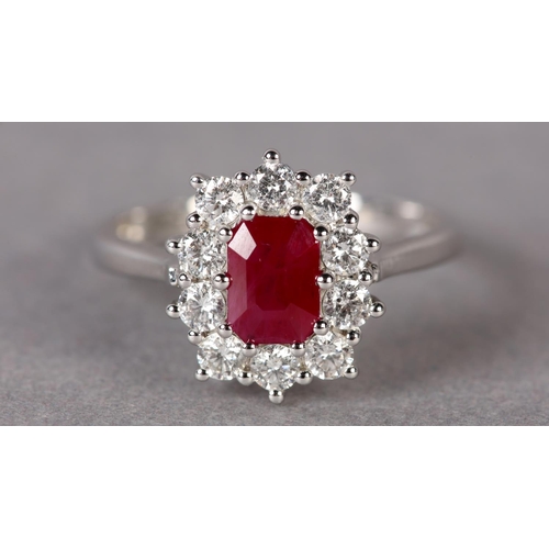 299 - A RUBY AND DIAMOND CLUSTER RING in 9ct white gold, claw set to the centre with a step cut ruby withi... 