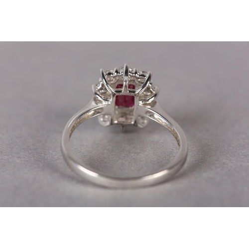 299 - A RUBY AND DIAMOND CLUSTER RING in 9ct white gold, claw set to the centre with a step cut ruby withi... 