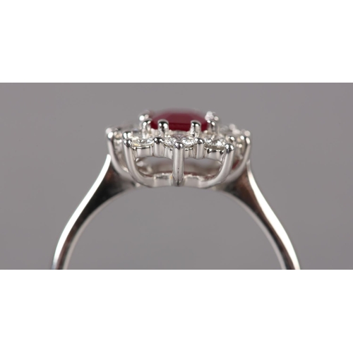 299 - A RUBY AND DIAMOND CLUSTER RING in 9ct white gold, claw set to the centre with a step cut ruby withi... 