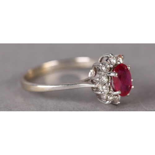 316 - A RUBY AND DIAMOND RING in 18ct gold, the oval faceted ruby claw set and raised against a surround o... 