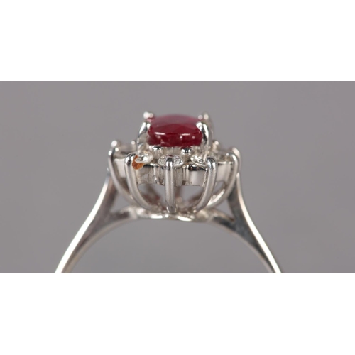 316 - A RUBY AND DIAMOND RING in 18ct gold, the oval faceted ruby claw set and raised against a surround o... 