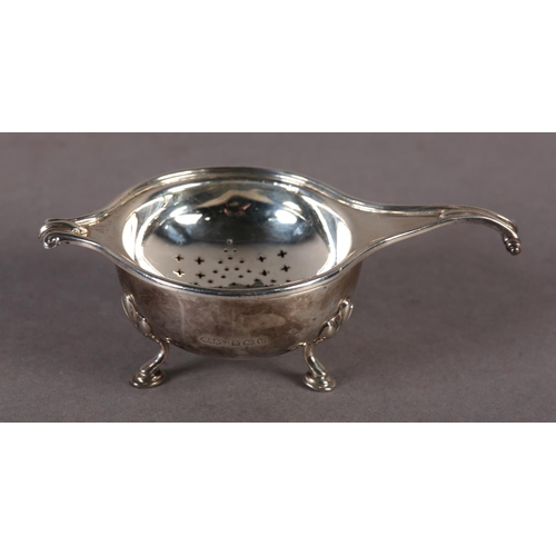 239 - A GEORGE V SILVER TEA STRAINER AND BOWL by Greenwood & Sons, Huddersfield with knurled scroll handle... 