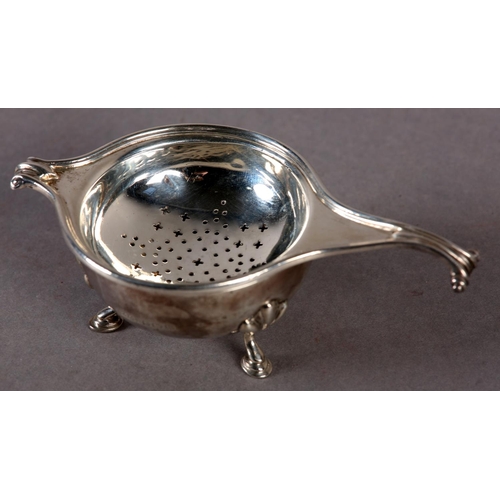 239 - A GEORGE V SILVER TEA STRAINER AND BOWL by Greenwood & Sons, Huddersfield with knurled scroll handle... 