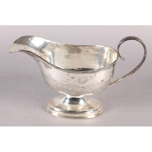 240 - A LATE VICTORIAN SILVER SAUCE BOAT of oval outline, C scroll handle, reeded edge and stepped foot, a... 