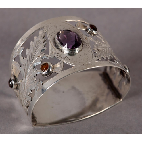 282 - AN EDWARD VII AMETHYST AND CITRINE SET NAPKIN RING, the oval faceted amethyst collet set to the cent... 